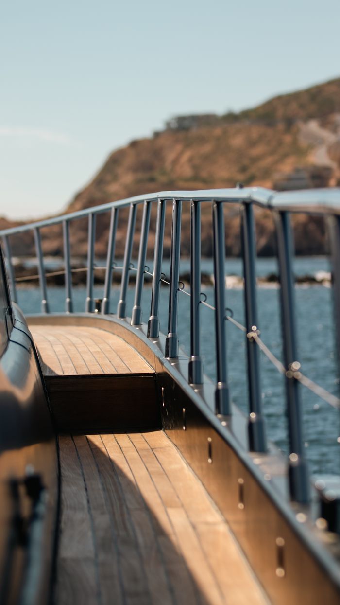 services-03 Elegant yacht deck overlooking ocean and rocky landscapes in Cabo San Lucas. Perfect for luxury travel imagery.